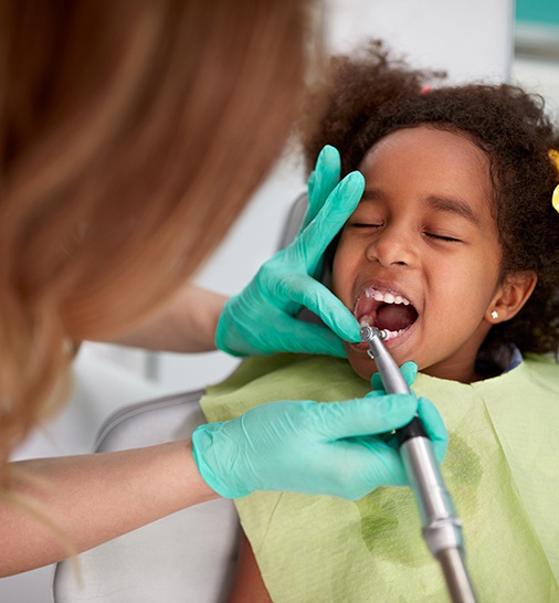 a child having their teeth cleaned by a dental hygienist