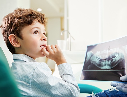 a child looking at a dental X-ray