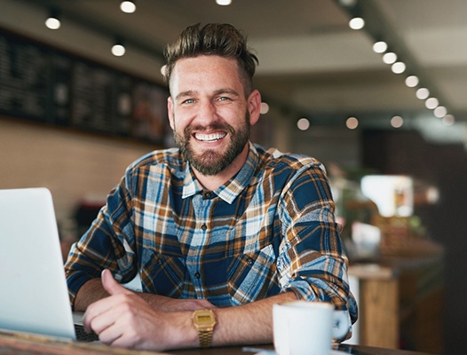 a man in a coffee shop smiling